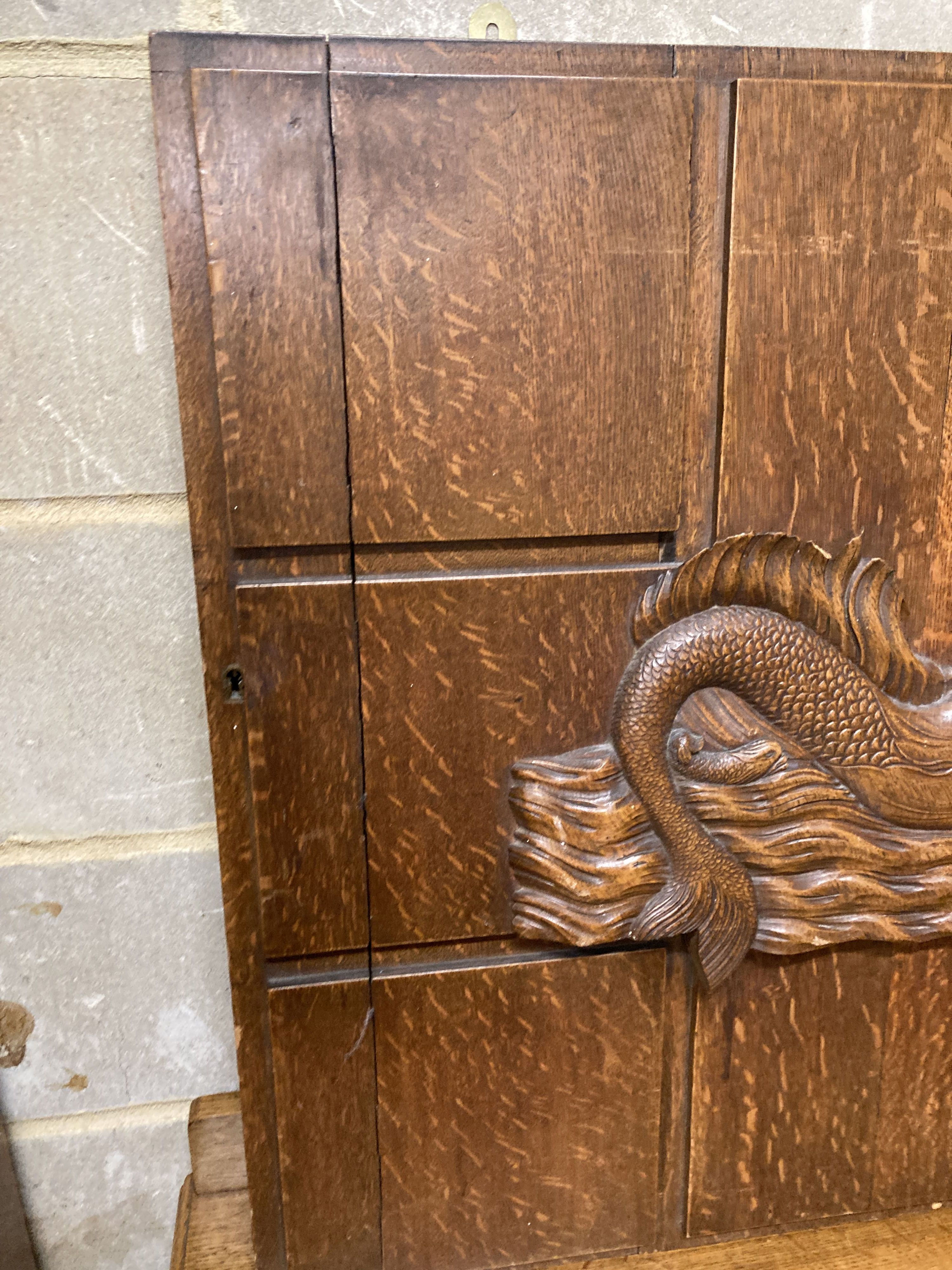 A mid 20th century rectangular oak panel carved with a mermaid formerly a cabinet door, width 81cm, depth 74cm